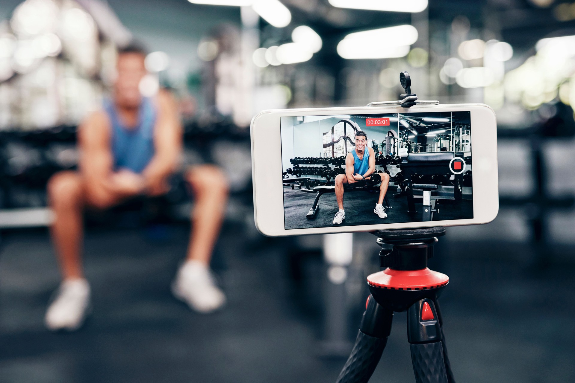 Gym, social media and fitness influencer with phone live streaming workout for interactive multimedia broadcast. Vlog, man filming arm exercise and training coach video recording online blog tutorial